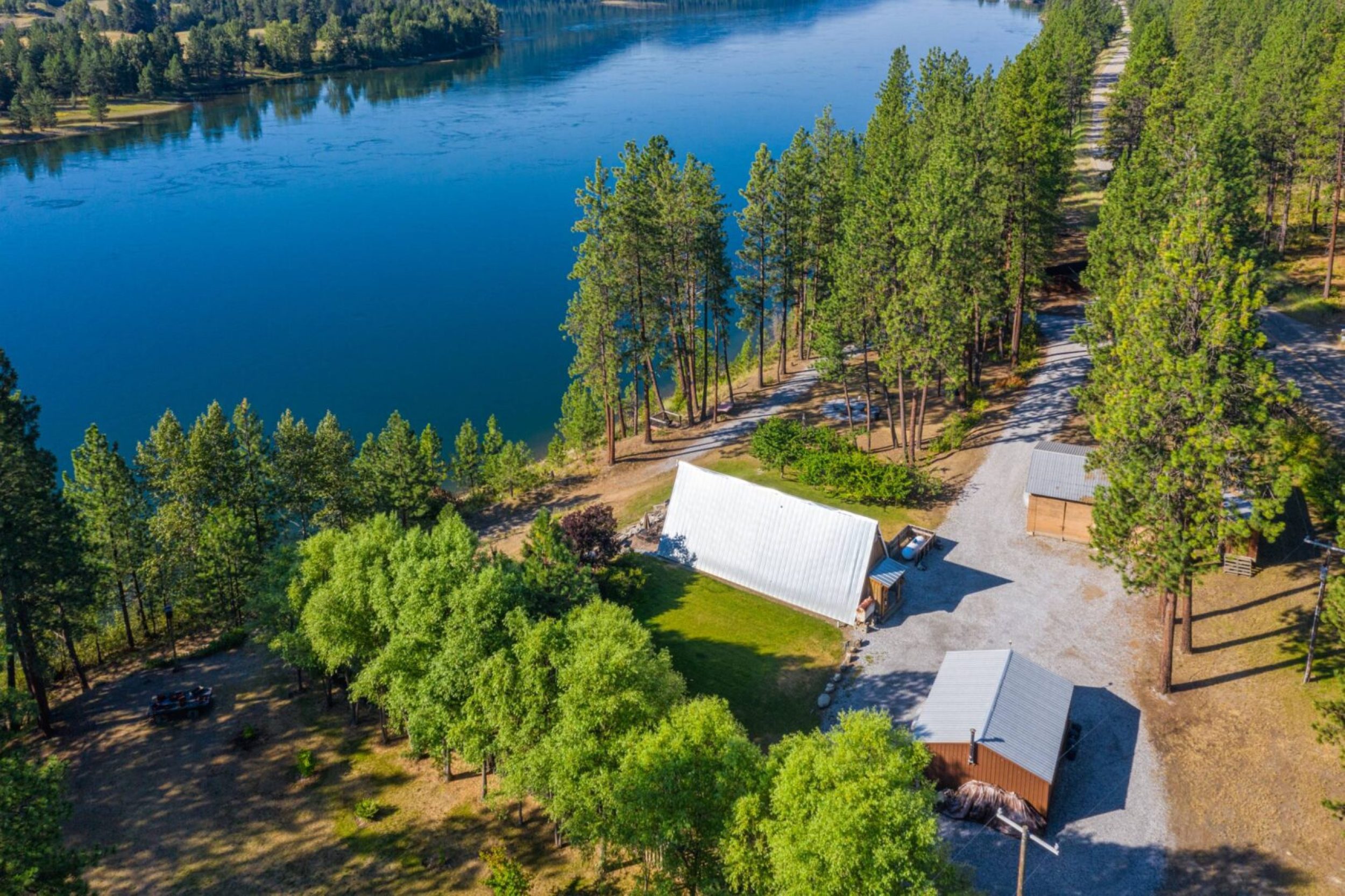 Aerial view of lakeside cabins and trees.