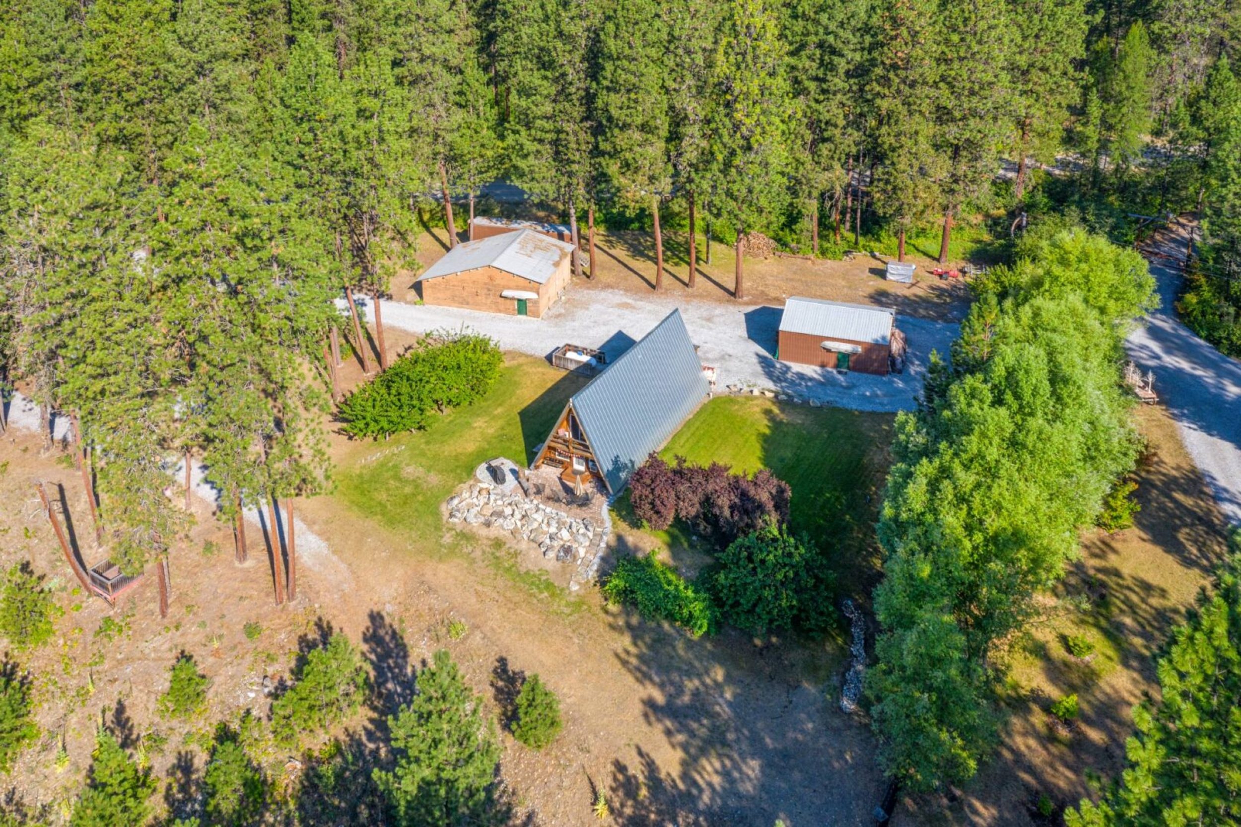 Aerial view of cabin in forest setting.