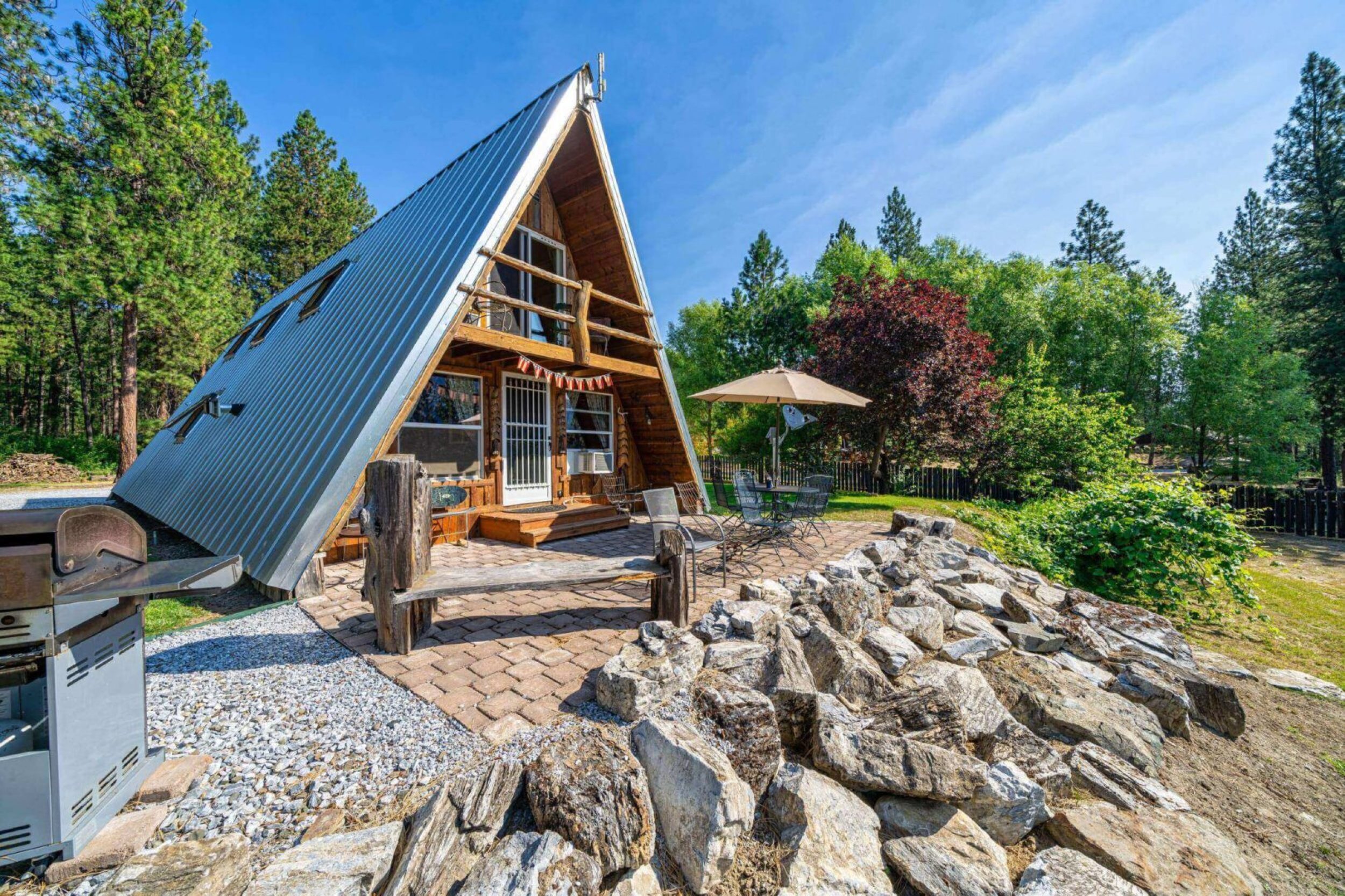 A-frame cabin in a wooded setting.