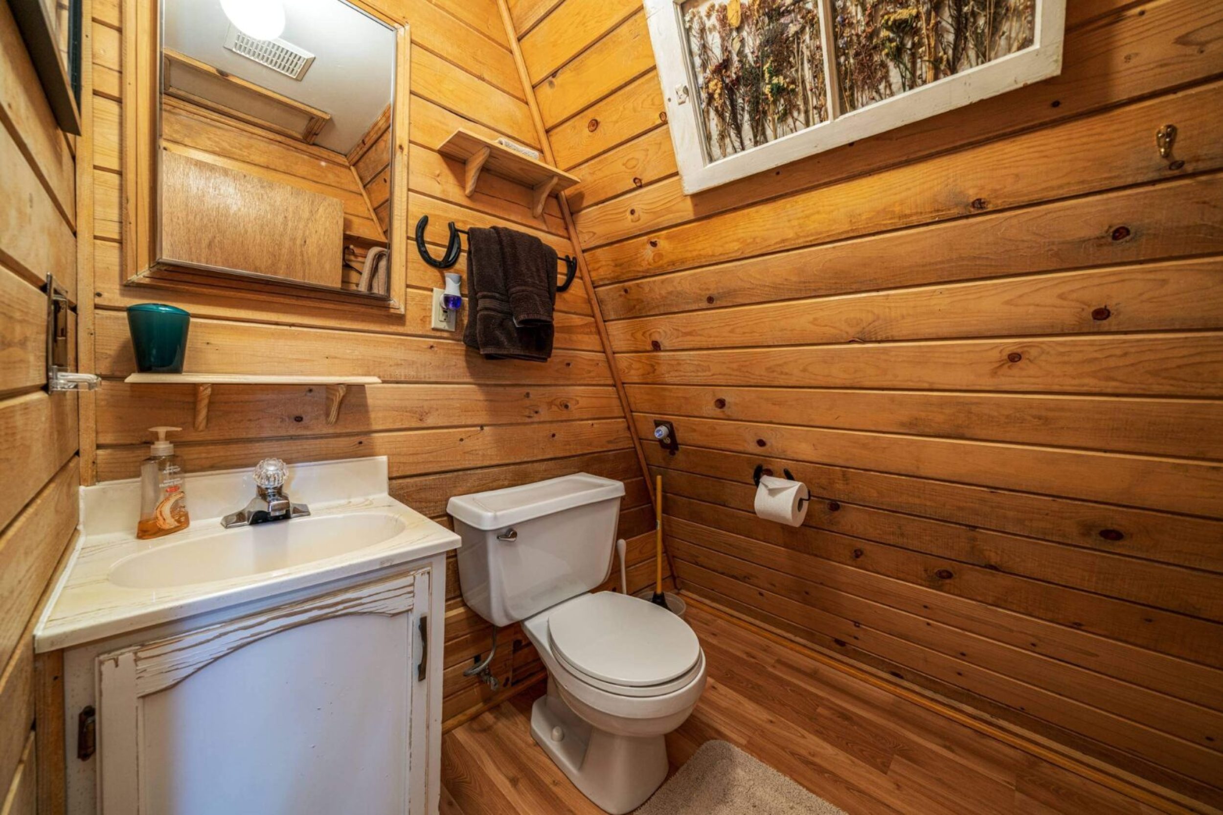 Rustic wooden bathroom with sink and toilet.