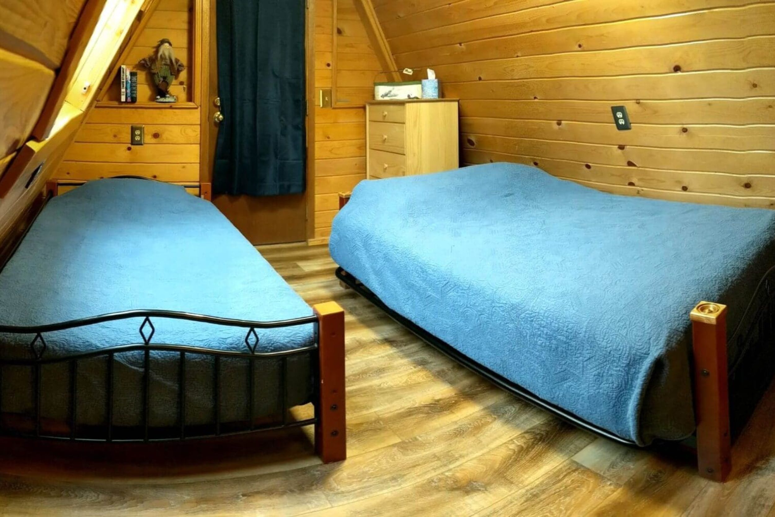 Cozy wooden attic bedroom with two beds.